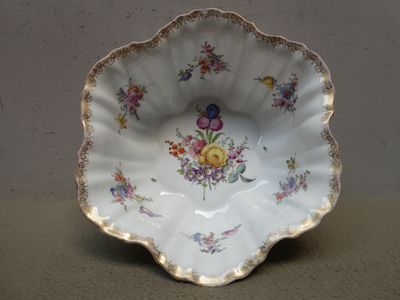 un bol blanc orné de fleurs, posé sur une table