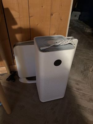 deux purificateurs d'air posés au sol, l'un à côté de l'autre