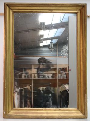 un miroir à cadre doré accroché au mur d'un magasin
