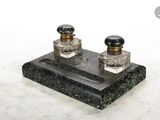 deux flacons de parfum posés sur un socle en marbre