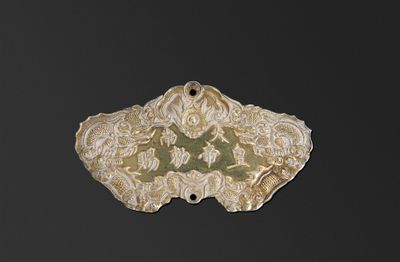 une image représentant un pendentif en brocart doré et vert sur fond noir