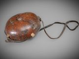 an old leather bag with a strap on a grey background