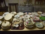 de nombreuses assiettes et bols posés sur une table, avec une commode en arrière-plan