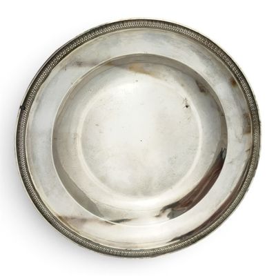 une assiette ancienne en argent, avec un bord perlé sur un fond blanc