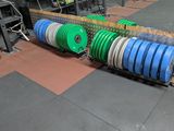 many different colored discs stacked on a rack in a gym