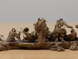 figurines of people in a boat on a wooden surface