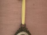 a clock hanging on the wall with a yellow bow