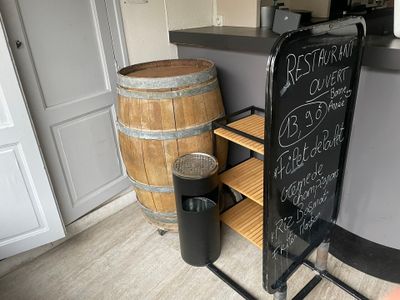 une ardoise posée sur un support à côté d'un tonneau de vin