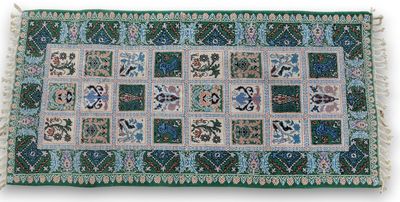 un tapis vert et bleu orné de fleurs et de feuilles