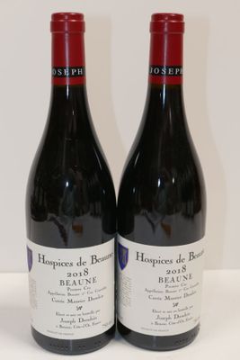 deux bouteilles de vin rouge posées sur une table blanche