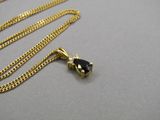 un gros plan d'un collier en or orné d'une pierre noire