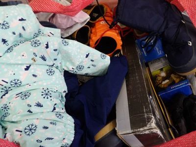 a baby sleeping in a suitcase full of clothes