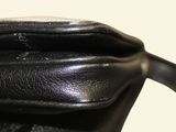 a close up of a black purse on a table