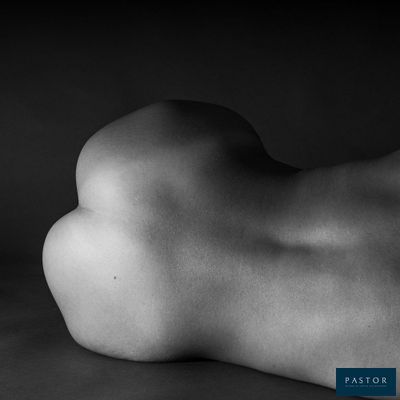 photographie en noir et blanc d'une femme nue allongée sur une table