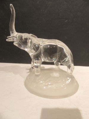 une figurine d'éléphant en verre transparent posée sur une table blanche