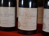 three bottles of wine sitting on a red cloth