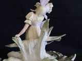 a figurine of a woman on a boat on a body of water