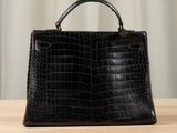 a black handbag sitting on top of a wooden table
