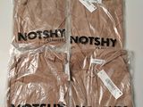 quatre t-shirts sont emballés dans des sacs en plastique sur une table