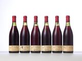 six bottles of wine lined up in a row on a table