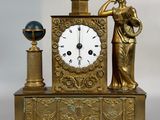 une horloge en or représentant une dame tenant un oiseau et un globe terrestre