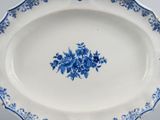 blue and white platter with flowers on it on a table