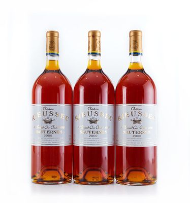 trois bouteilles de vin sont alignées sur une surface blanche
