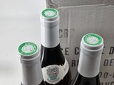 three bottles of wine in a box on the table