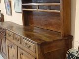 a wooden cabinet with a book shelf on top of it