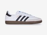 une paire de baskets Adidas blanches et noires sur fond blanc
