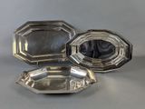 deux plateaux en métal argenté posés sur une table, avec un miroir en arrière-plan