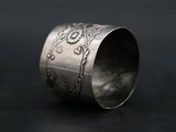 a close up of a silver ring on a black surface