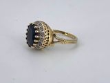 a gold ring with a blue stone surrounded by diamonds