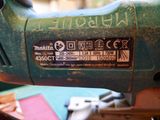 a close up of a green electric tool on a table