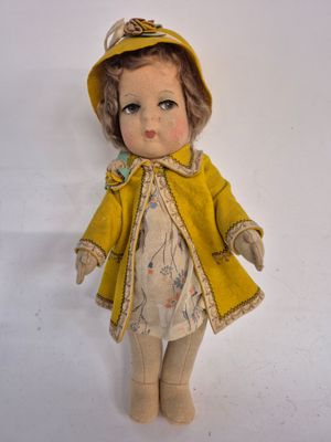 a doll that is wearing a yellow coat and hat