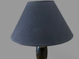 black and gold table lamp with a blue shade on a gray background