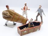 three figurines of people that are standing next to a box