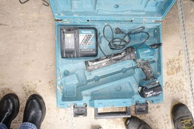 a blue tool box with tools in it and a pair of black shoes