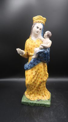 une figurine représentant une femme tenant un bébé dans ses bras