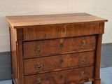 une petite commode en bois dans une pièce