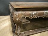a wooden table with a glass top on a wooden floor