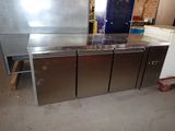 three stainless steel refrigerators sitting in a room