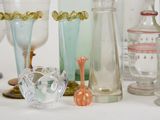 many glass vases sitting on a table next to each other