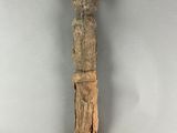 une vieille statue en bois d'un homme avec un chapeau sur la tête