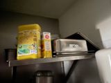 a metal shelf with food on it in a kitchen