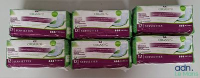 six boîtes de serviettes hygiéniques bio posées sur un comptoir blanc