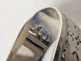 a close up of a silver bracelet on a table