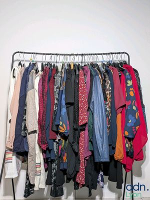 a lot of clothes hanging on a rack in a room