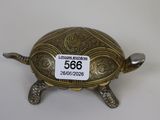 une figurine antique en laiton représentant une tortue, avec une étiquette de prix sur le dos