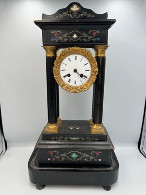 a black and gold clock sitting on top of a table